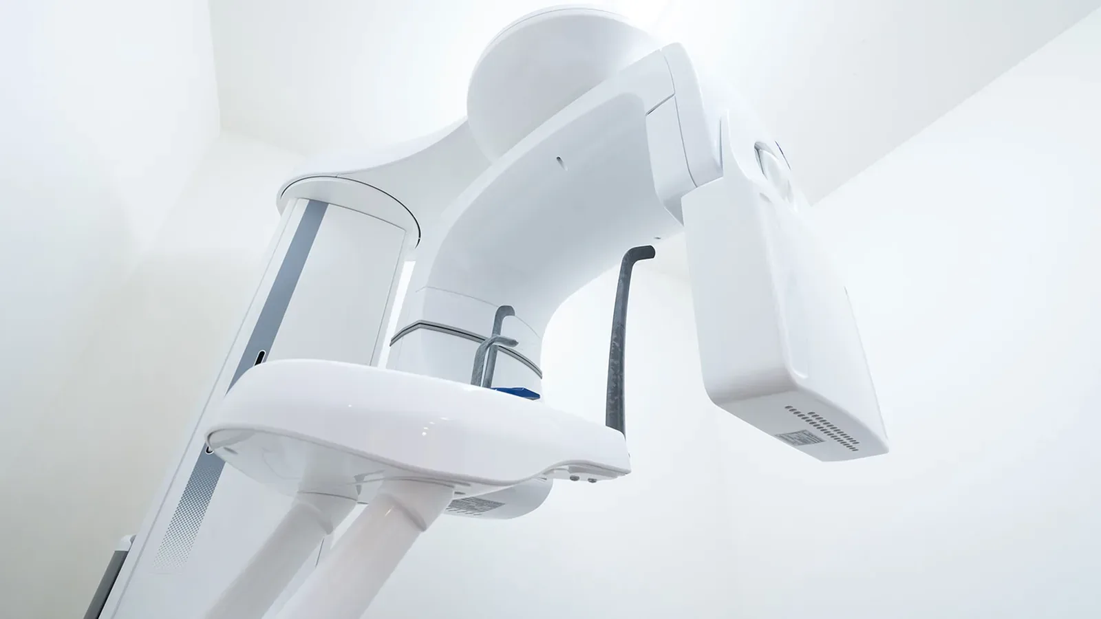 歯科用CT・パノラマX線撮影装置を天井付近から見上げた白色の医療機器の画像